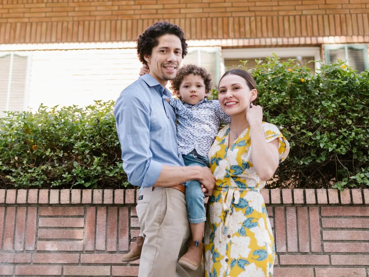 Pareja con su hijo frente a su casa